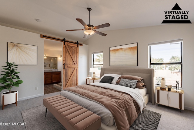 bedroom featuring carpet flooring, lofted ceiling, a barn door, and multiple windows