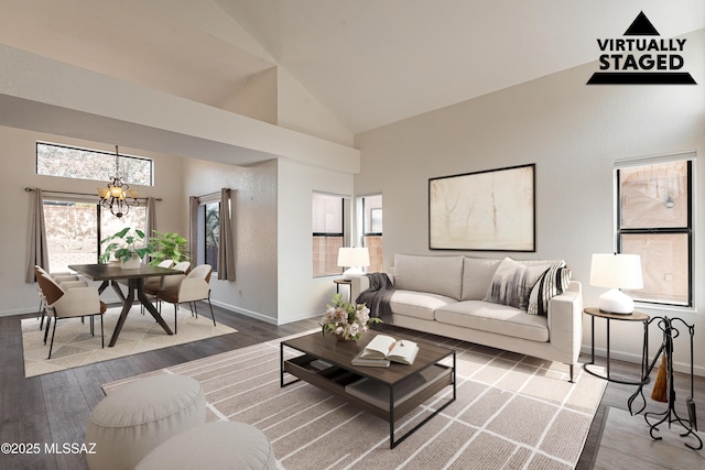 living room featuring a healthy amount of sunlight, wood finished floors, and an inviting chandelier