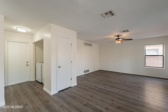 spare room featuring washer / clothes dryer, ceiling fan, and dark hardwood / wood-style flooring