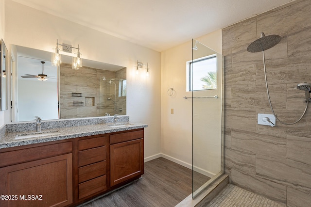 bathroom featuring tiled shower, vanity, and wood-type flooring