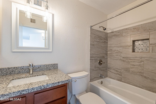 full bathroom featuring tiled shower / bath combo, vanity, and toilet