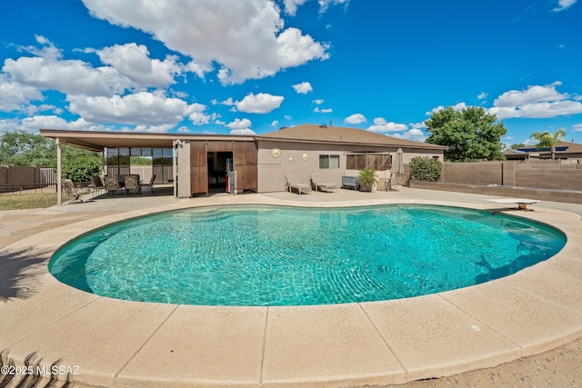 view of swimming pool featuring a diving board and a patio area