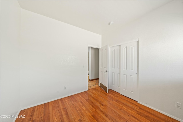 unfurnished bedroom featuring wood-type flooring and a closet