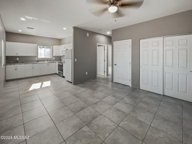 kitchen featuring ceiling fan, white cabinets, white refrigerator, stainless steel range with electric stovetop, and light tile patterned floors