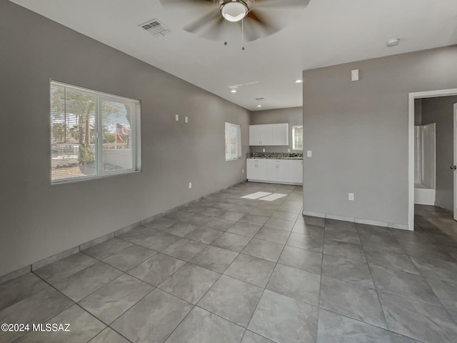 unfurnished living room with light tile patterned floors and ceiling fan