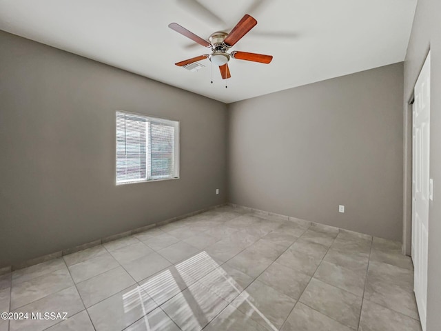 unfurnished room with ceiling fan and light tile patterned floors