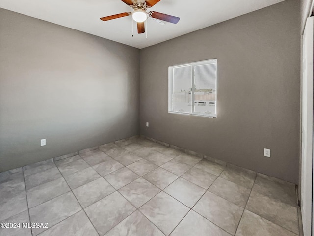 tiled spare room with ceiling fan