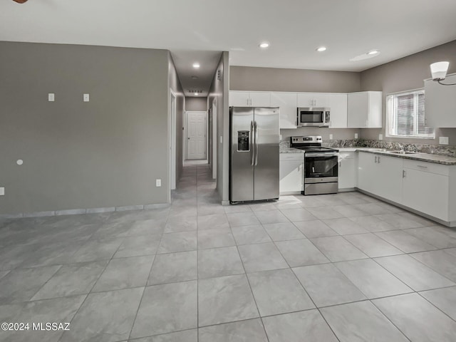 kitchen featuring light tile patterned flooring, sink, white cabinetry, and stainless steel appliances