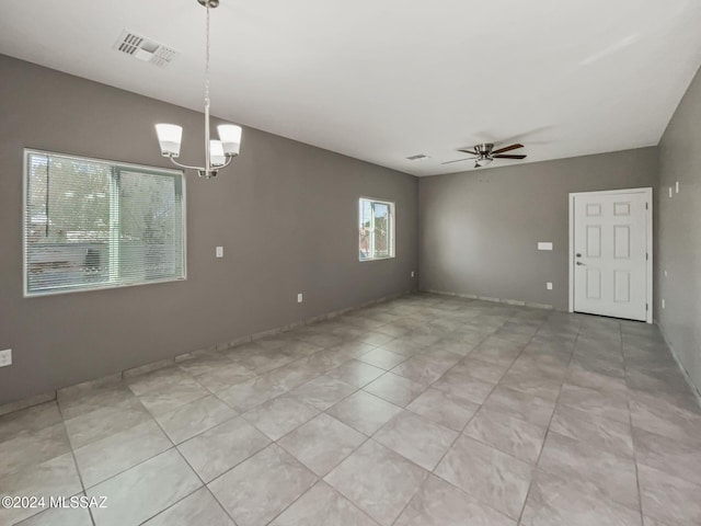 empty room with ceiling fan with notable chandelier