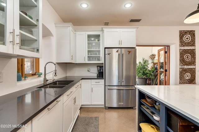 kitchen with white cabinetry, sink, and high quality fridge