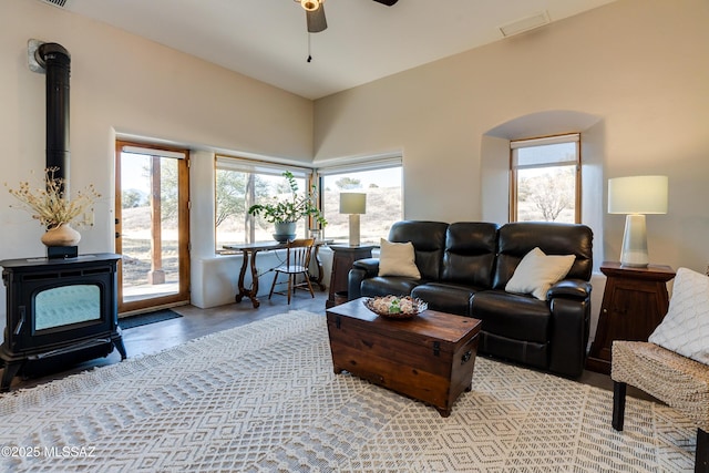 living room with a wood stove and ceiling fan