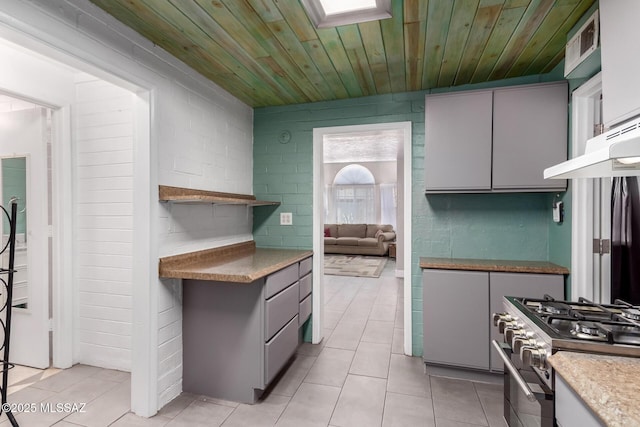 kitchen with wooden ceiling, light tile patterned floors, stainless steel stove, and gray cabinets