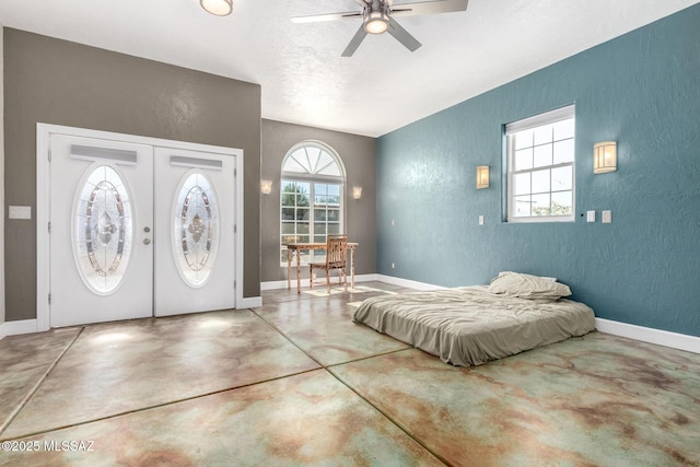 entrance foyer with ceiling fan, french doors, and concrete flooring