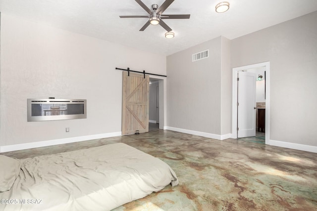 unfurnished bedroom with ceiling fan, a barn door, heating unit, and concrete floors