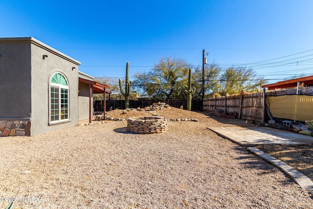 view of yard with an outdoor fire pit and a patio