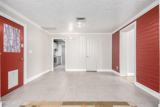 entryway with brick wall, crown molding, and a textured ceiling