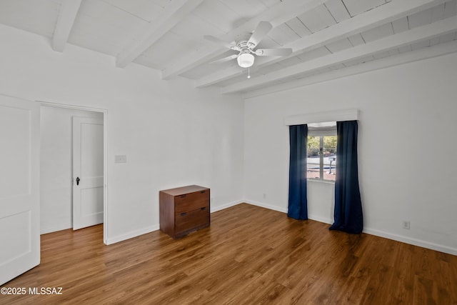 unfurnished room with baseboards, beam ceiling, and wood finished floors