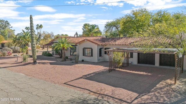 mediterranean / spanish-style house with stucco siding, a garage, and a tile roof