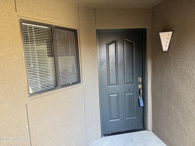 property entrance featuring stucco siding