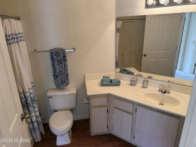 bathroom featuring baseboards, toilet, a shower with curtain, wood finished floors, and vanity