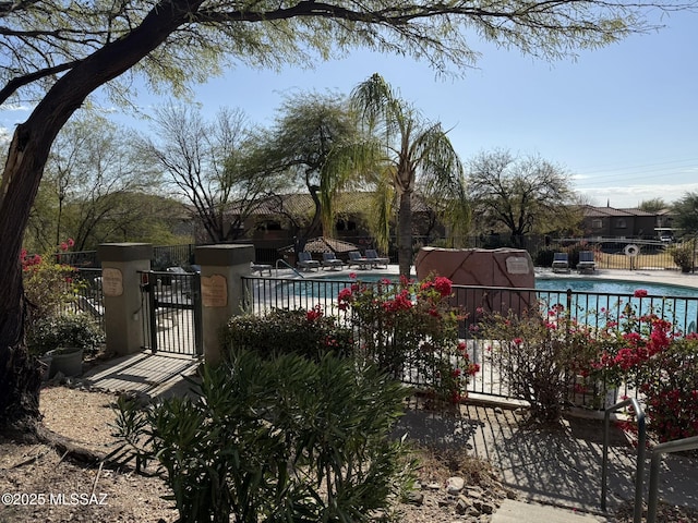 community pool featuring a gate, a patio, and fence