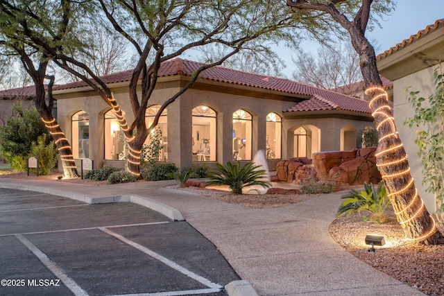 mediterranean / spanish house featuring stucco siding and a tile roof