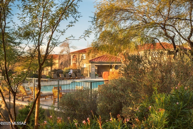 pool with a patio area and fence