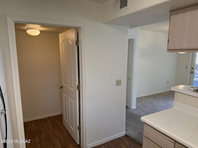 kitchen with visible vents, light countertops, baseboards, and dark wood-style flooring