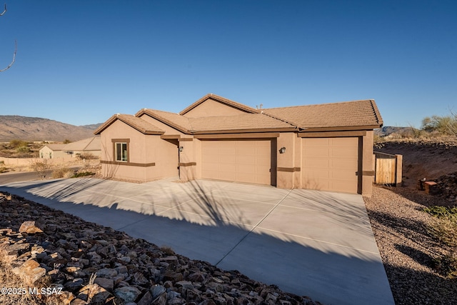 single story home featuring a mountain view and a garage