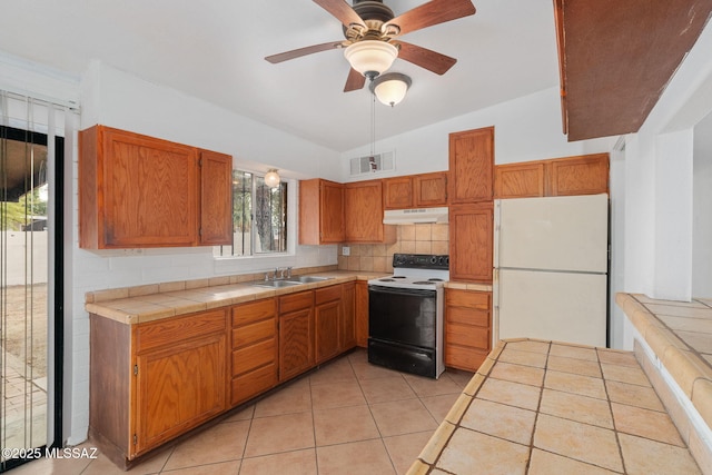 kitchen featuring ceiling fan, sink, tile countertops, lofted ceiling, and white appliances