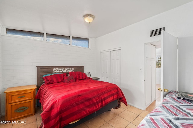 bedroom with a closet and light tile patterned flooring