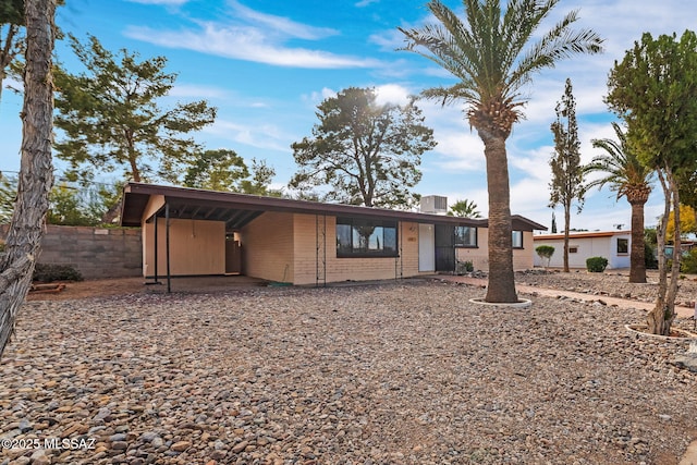 ranch-style home with a carport and central AC