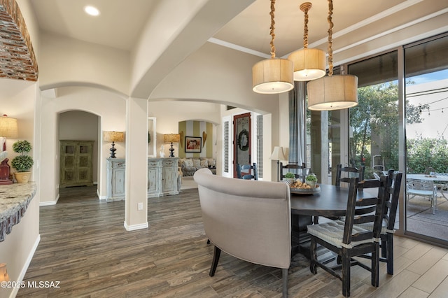 dining area featuring a high ceiling and dark wood-type flooring