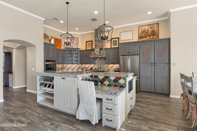 kitchen with appliances with stainless steel finishes, backsplash, dark hardwood / wood-style flooring, gray cabinets, and white cabinetry