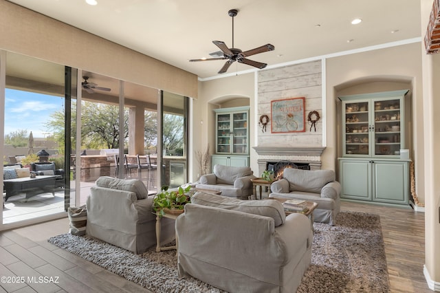 living room with a wealth of natural light, crown molding, and wood-type flooring