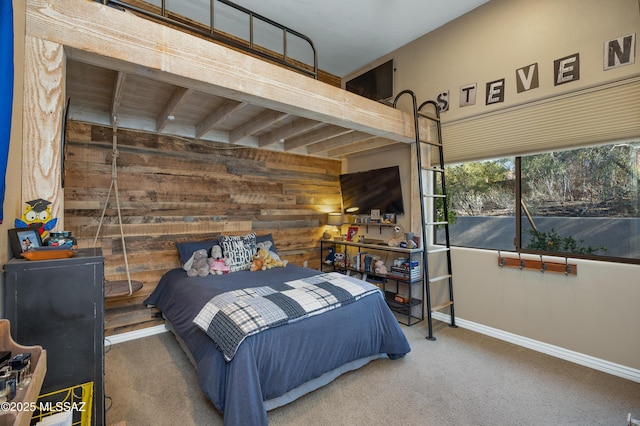 carpeted bedroom featuring wood walls