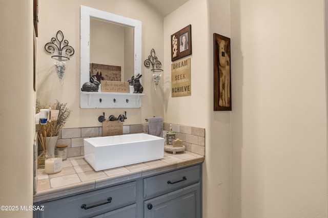 bathroom with vanity, lofted ceiling, and backsplash