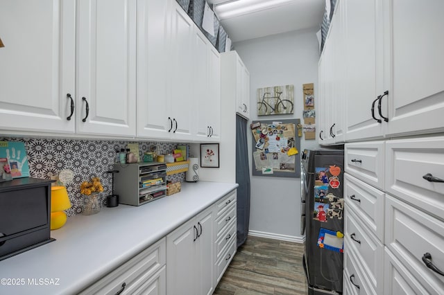 kitchen featuring dark hardwood / wood-style floors, tasteful backsplash, white cabinetry, and fridge