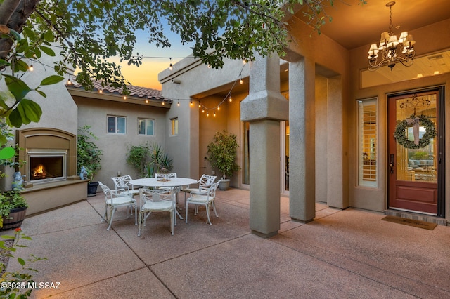 patio terrace at dusk with exterior fireplace