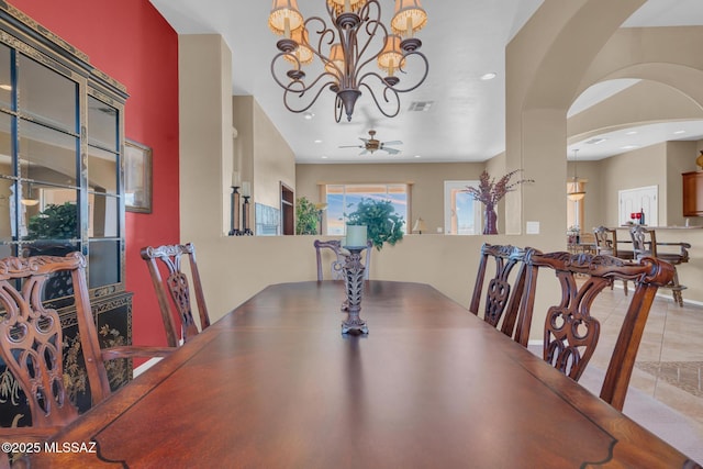 tiled dining space with ceiling fan with notable chandelier