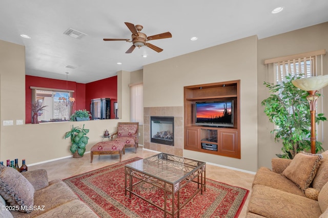 living room with ceiling fan and a fireplace