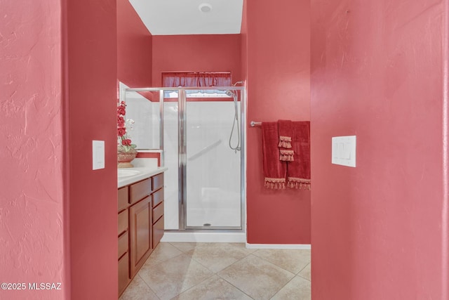 bathroom with an enclosed shower, vanity, and tile patterned flooring