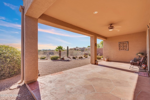 patio terrace at dusk featuring ceiling fan