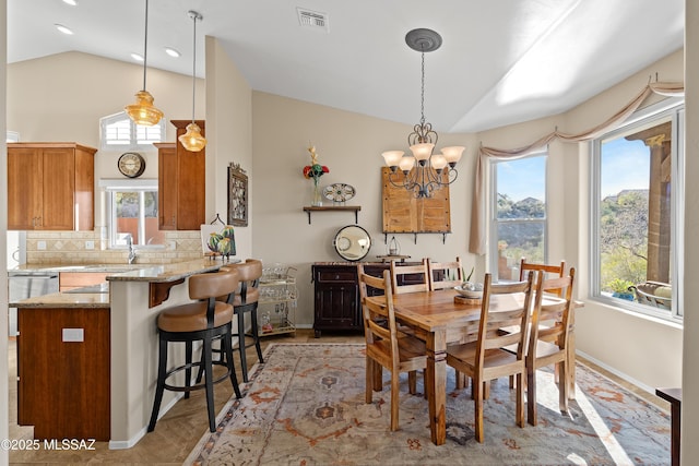 dining room featuring an inviting chandelier and vaulted ceiling