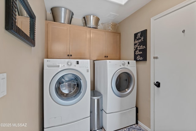 laundry room featuring cabinets and washer and dryer