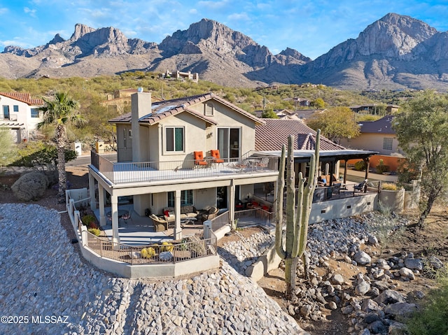 rear view of house featuring a mountain view, outdoor lounge area, and a patio