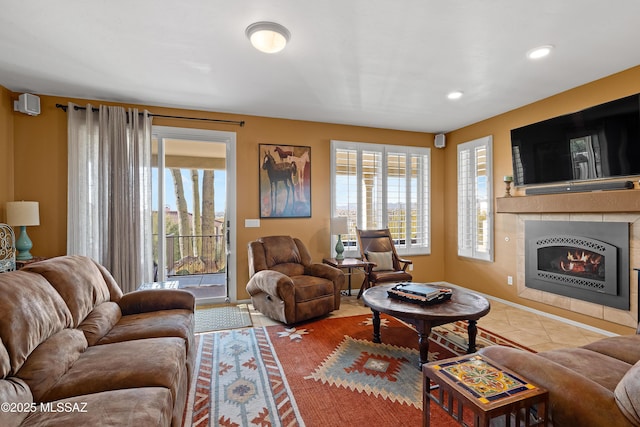 living room featuring tile patterned floors, a healthy amount of sunlight, and a tiled fireplace