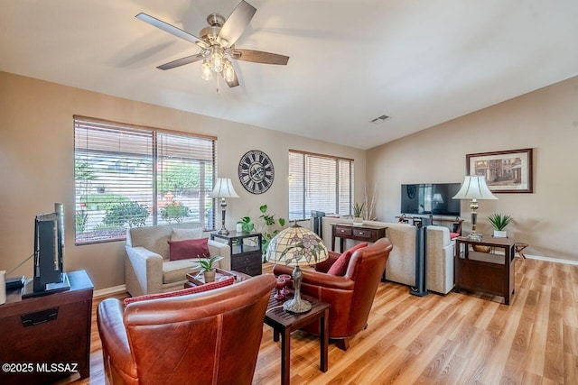 living room with lofted ceiling, ceiling fan, and light wood-type flooring