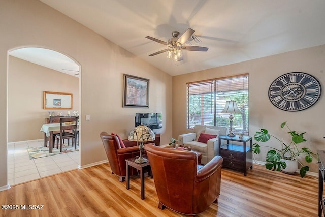 sitting room with ceiling fan, light wood-type flooring, and vaulted ceiling