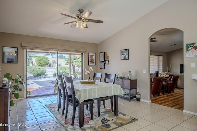 dining room with ceiling fan, lofted ceiling, and light tile patterned flooring